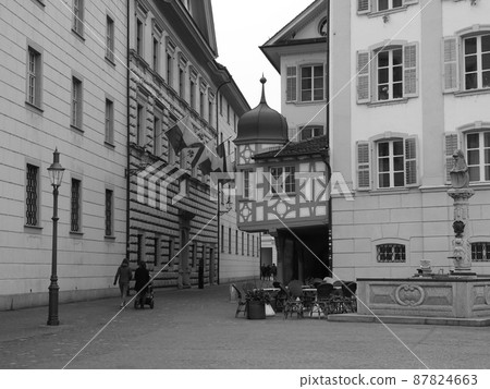 Old ornate timber framework and small tower on the edge of a historic house in Lucerne. 87824663