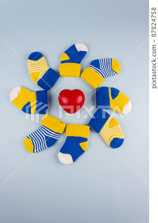 World Down Syndrome Day background. Different socks with heart on blue background. Down syndrome awareness concept. Odd socks as symbol of Down Syndrome. World Down Syndrome Day background. Different socks with heart on blue background. Down syndrome awareness concept. Odd socks as symbol of Down Syndrome. 87824758