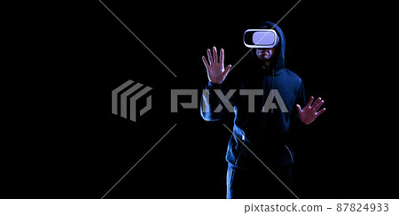 Virtual reality glass vr. Young man in digital glasses for 3d virtual reality game on dark background. Augmented reality, game, future technology concept. VR. Virtual reality glass vr. Young man in digital glasses for 3d virtual reality game on dark background. Augmented reality, game, future technology concept. VR. 87824933