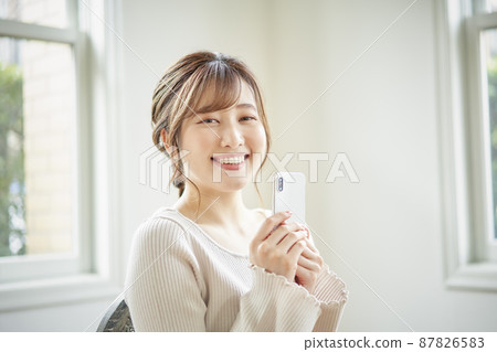 看智能手機的女人的肖像 87826583