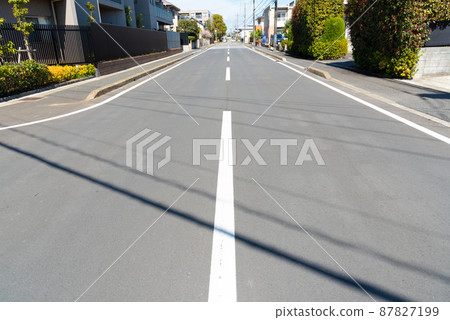 A straight road leading to a residential area 87827199
