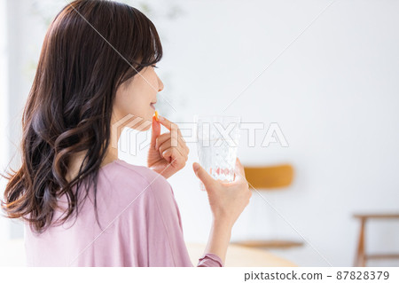 穿著休閒服的女性飲用膠囊片 87828379