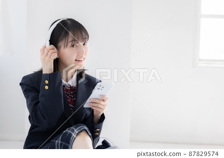 一個高中女生的肖像 高中女生戴著耳機聽音樂 87829574