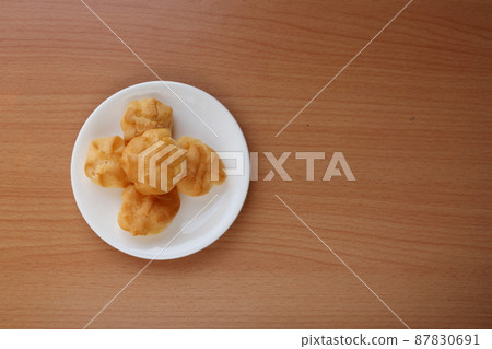 Eclair on white dish and wood background. 87830691