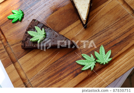 Triangle shape browie with cannabis on wood plate. Triangle shape browie with cannabis on wood plate. 87830751