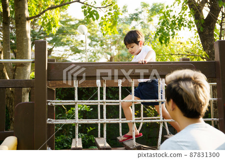 Happy Asian little boy enjoy playing and walking at the park with daddy close up, Asian boy have a beautiful smiling while looking at his father. Little boy portrait at the park and playground. Happy Asian little boy enjoy playing and walking at the park with daddy close up, Asian boy have a beautiful smiling while looking at his father. Little boy portrait at the park and playground. 87831300
