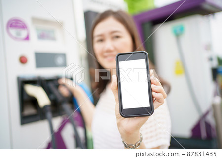 Empty screen of mockup smartphone isolated with clipping path. Asian young woman using ev charging application on smartphone connect with the charging station, BEV or electric vehicle charging station 87831435
