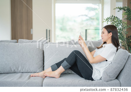 在沙發上使用智能手機的女人 在沙發上使用智能手機的女人 87832436