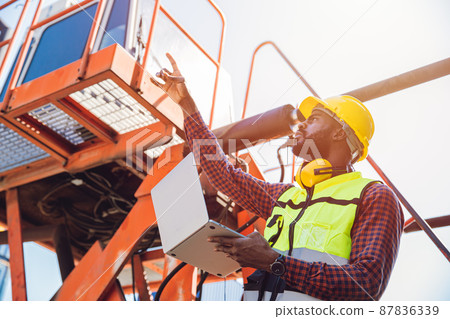 Portrait Black African staff worker happy smile working in cargo crane shipping logistic port. 87836339