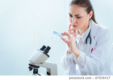 Scientist doctor look at Microscope slide with shock surprised expression form virus mutation test results 87836417