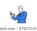 A businessman holding a smartphone 87837219