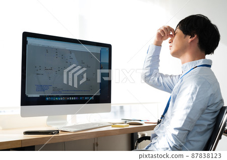 在電腦前一臉疲憊的男性電氣工程師 87838123