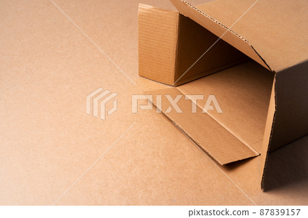 Cardboard box on beige background in studio 87839157