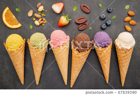 Various of ice cream flavor in cones blueberry ,pistachio ,almond ,orange and chocolate setup on dark stone background . Summer and Sweet menu concept. 87839390