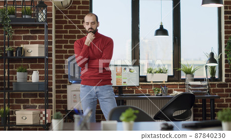 Indecisive employee walking around office and thinking about strategy to develop marketing project. Contemplative adult brainstorming ideas to work on financial analysis, pondering solution. Indecisive employee walking around office and thinking about strategy to develop marketing project. Contemplative adult brainstorming ideas to work on financial analysis, pondering solution. 87840230
