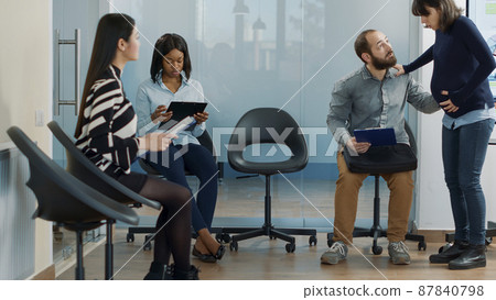 Male candidate attending job interview with pregnant employee, preparing for professional recruitment meeting in office. Woman inviting man to start job application appointment. Male candidate attending job interview with pregnant employee, preparing for professional recruitment meeting in office. Woman inviting man to start job application appointment. 87840798