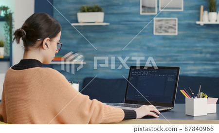 Female coder programming analytics report on technical interface, using hacking software to create binary code information and data. Programmer using virtual system and network on laptop. 87840966