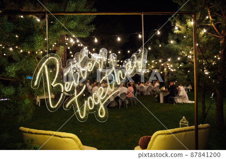 neon sign with the inscription in the garden. In the background grass and trees 87841200