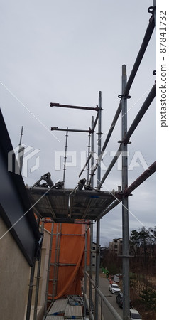 Construction site. Exterior scaffolding. Equipment. Window frame. Construction site. Exterior scaffolding. Equipment. Window frame. 87841732
