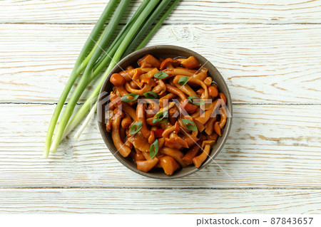 Bowl of marinated mushrooms on white wooden table 87843657