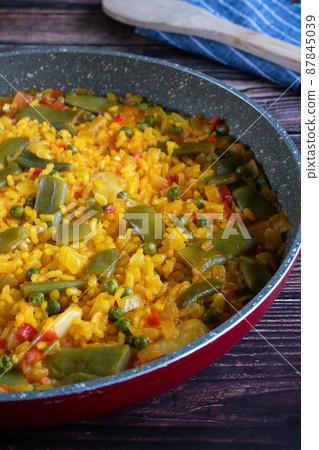 Rice paella with vegetables on a rustic background Rice paella with vegetables on a rustic background 87845039