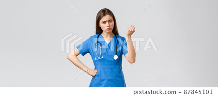 Medical workers, healthcare, covid-19 and vaccination concept. Angry and grumpy young female nurse, doctor scolding young patient breaking quarantine rules, shaking fist in threat Medical workers, healthcare, covid-19 and vaccination concept. Angry and grumpy young female nurse, doctor scolding young patient breaking quarantine rules, shaking fist in threat 87845101