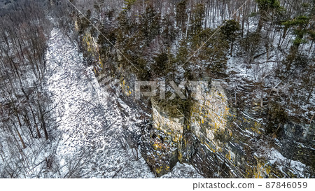 A steep icy ledge in the forest A steep icy ledge in the forest 87846059