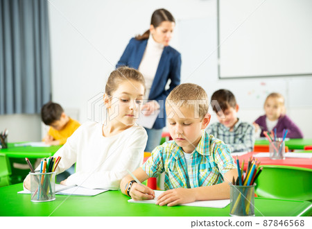 Portrait of schoolchildren sitting in classroom and chatting during lesson Portrait of schoolchildren sitting in classroom and chatting during lesson 87846568