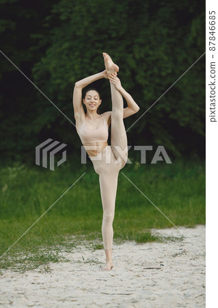 Woman practicing advanced yoga on a summer beach Woman practicing advanced yoga on a summer beach 87846685