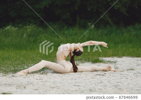 Woman practicing advanced yoga in a beach Woman practicing advanced yoga in a beach 87846699