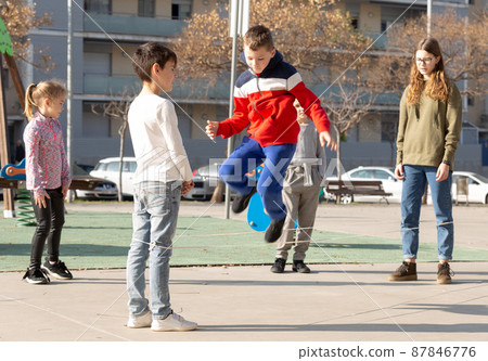 Children skipping on elastic jump rope Children skipping on elastic jump rope 87846776