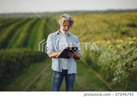 Old farmer in shirt standing on field with notebook Old farmer in shirt standing on field with notebook 87846793