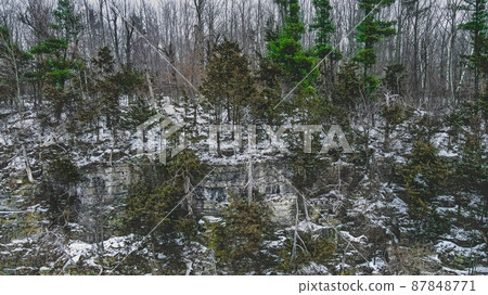 A steep icy ledge in the forest 87848771