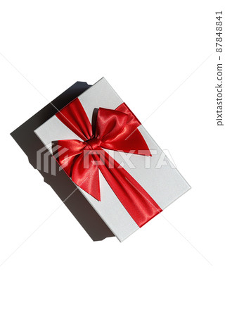Closed gift box with red ribbon isolated on white from above Closed gift box with red ribbon isolated on white from above 87848841