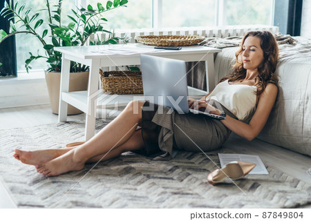 Young woman using laptop while lying on floor in bedroom at home Young woman using laptop while lying on floor in bedroom at home 87849804