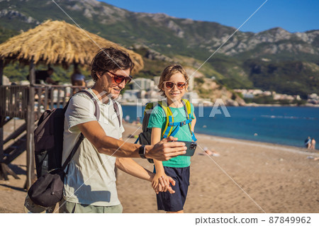 Dad and son tourists walks along the coast of Budva in Montenegro Dad and son tourists walks along the coast of Budva in Montenegro 87849962
