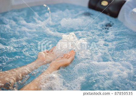 Portrait of young carefree happy smiling woman relaxing at hot tub during enjoying happy traveling moment vacation life against the background of green big mountains Portrait of young carefree happy smiling woman relaxing at hot tub during enjoying happy traveling moment vacation life against the background of green big mountains 87850535