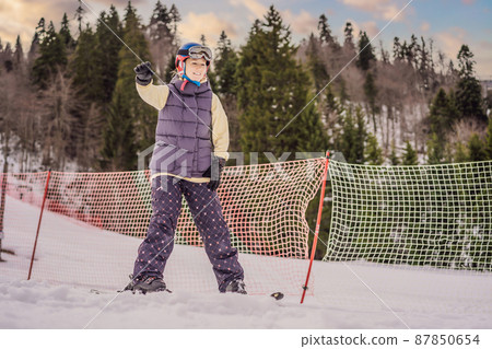 Woman learning to ski. Young woman skiing on a snowy road in the mountains Woman learning to ski. Young woman skiing on a snowy road in the mountains 87850654