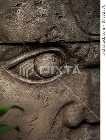 Olmec sculpture carved from stone. Mayan symbol - Big stone head statue in a jungle Olmec sculpture carved from stone. Mayan symbol - Big stone head statue in a jungle 87852576