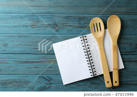 Empty recipe book and utensils on wooden table 87853996