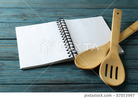 Empty recipe book and utensils on wooden table 87853997
