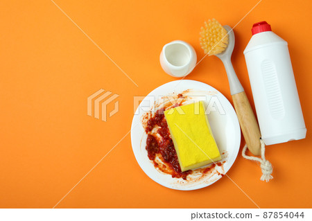 Concept of Dishwashing detergent accessories on orange background Concept of Dishwashing detergent accessories on orange background 87854044