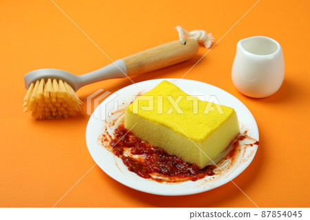 Concept of dirty dishes on orange background Concept of dirty dishes on orange background 87854045