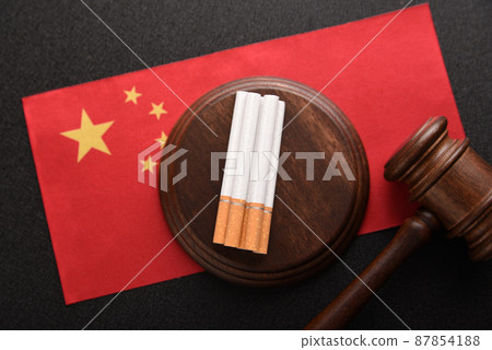 Cigarettes, wooden Judge gavel and flag of China. Smoking problem in China.Tobacco law. Tobacco control act 87854188