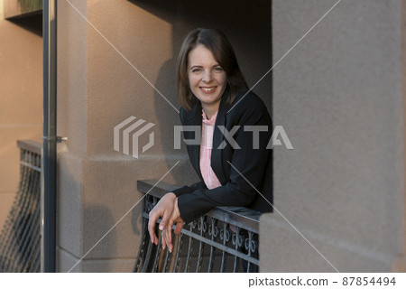 Portrait of successful business woman on the balcony. Smiling girl with bob haircut. Happy woman on break Portrait of successful business woman on the balcony. Smiling girl with bob haircut. Happy woman on break 87854494