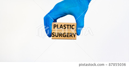 Plastic surgery symbol. Doctor hand in blue glove holds wooden blocks with words Plastic surgery, beautiful white background. Medical and plastic surgery concept. 87855036