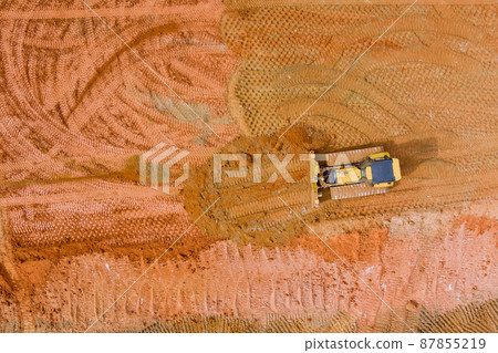 Panoramic top view of work backhoe digging soil and loads a dump truck with earth 87855219