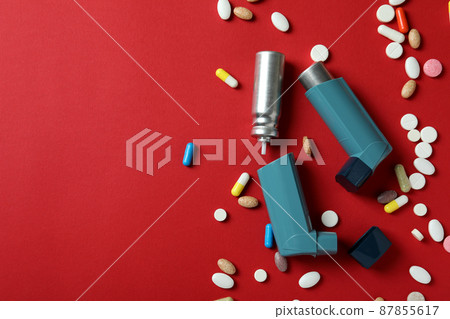 Asthma treatment accessories on red background, top view Asthma treatment accessories on red background, top view 87855617