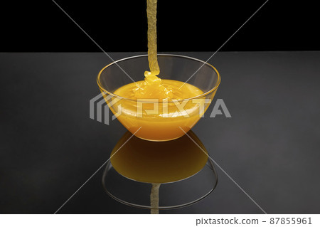 Fresh floral honey flows into a transparent plate in a mirror image. Organic Vitamin Health Food 87855961
