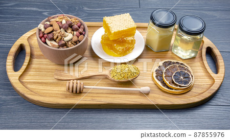 assortment of nuts and assorted dried citrus fruits and fresh floral honeycomb  87855976